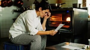 A chef sitting alone in her kitchen rethinking whether her restaurant could ever run without her
